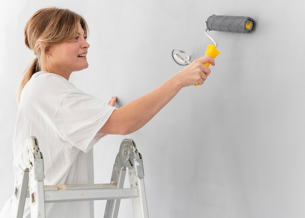 Woman painting wall with roller