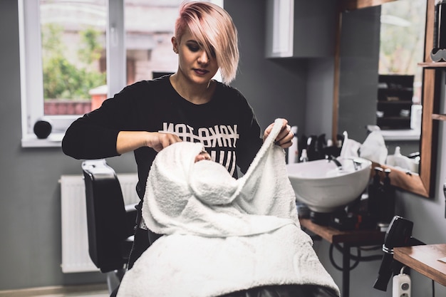 Woman pampering face of client in salon