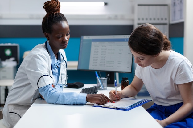 Woman patient signing medical documents discussing medication treatment