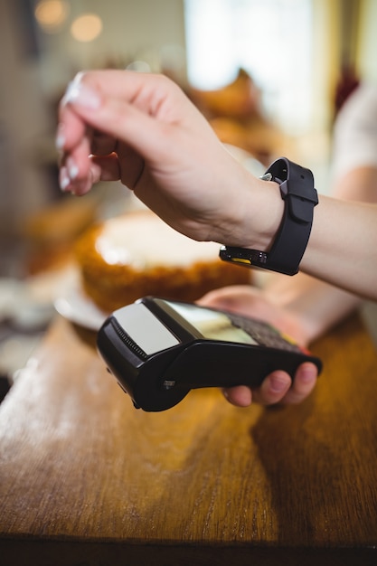 Woman paying bill through smartwatch using NFC technology