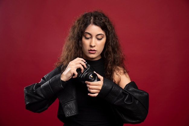 Free photo woman photographer in all black outfit holding a camera .