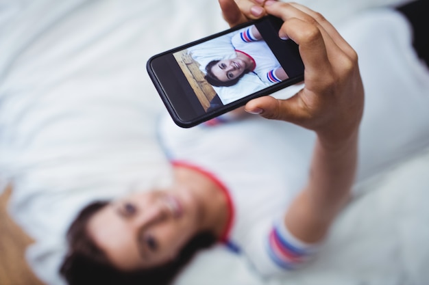 Woman photographing herself on mobile phone