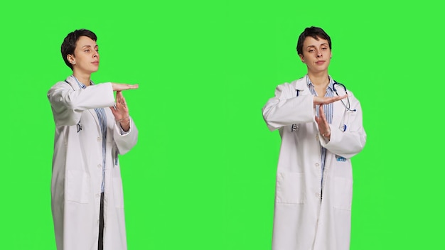 Free photo woman physician doing timeout gesture against greenscreen backdrop