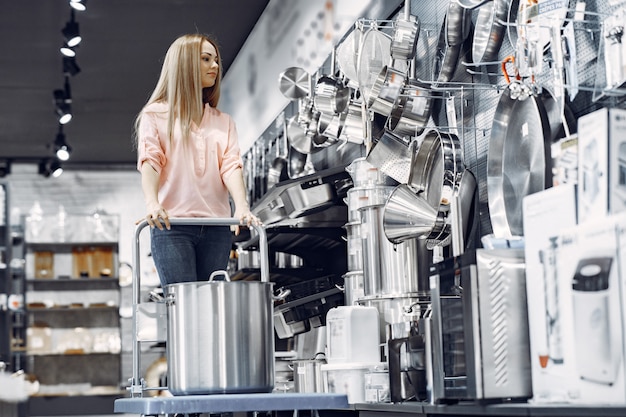 Free photo woman in a pink blouse buys dishes in the store