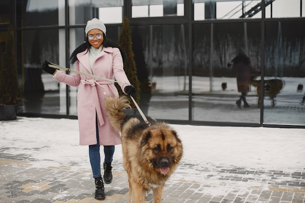 Free Photo woman in a pink coat with dog