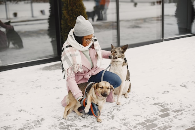 Free Photo woman in a pink coat with dogs