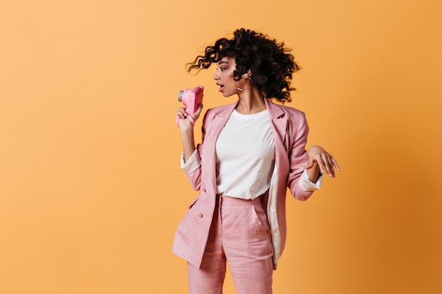 Woman in pink suit holding front