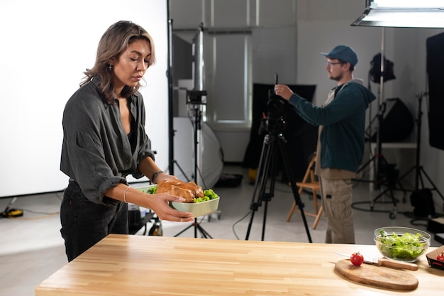 Free photo woman placing a bowl of food for the movie team