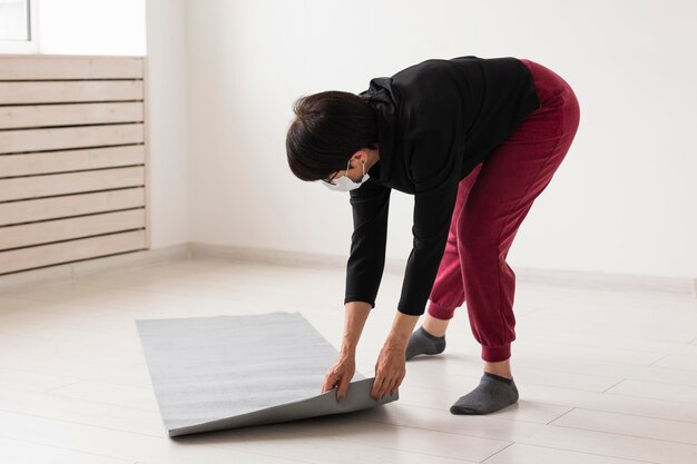 Woman placing a fitness mat on the floor