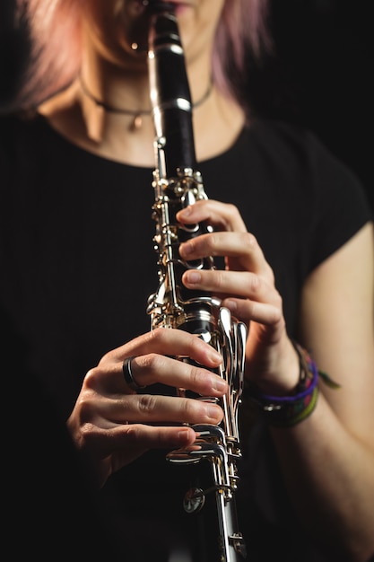 Free photo woman playing a clarinet in music school