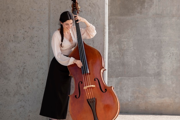 Free Photo woman playing double bass medium shot