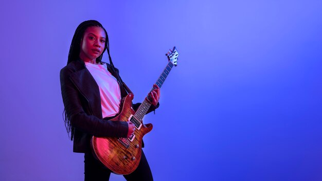 Woman playing the guitar side view