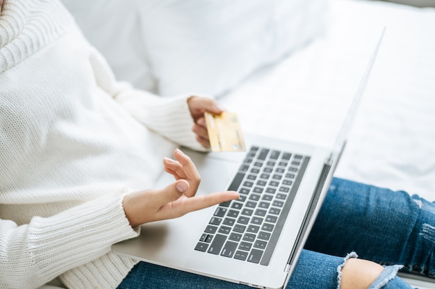 Free Photo woman playing laptop and hold a credit card.