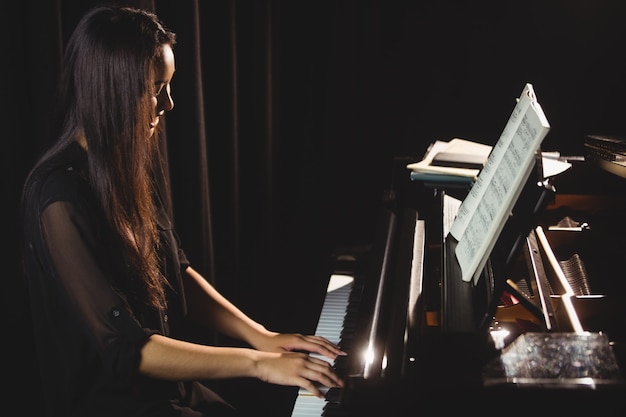 Woman playing a piano in music studio