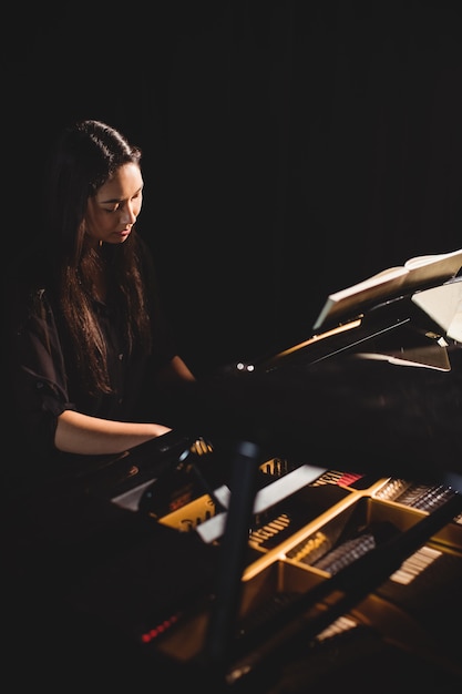 Woman playing a piano in music studio