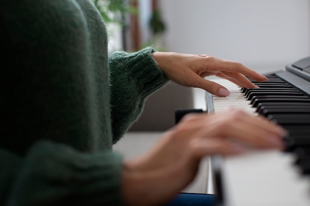 Free photo woman playing piano side view