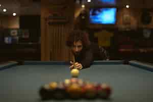 Free photo woman playing pool at a bar