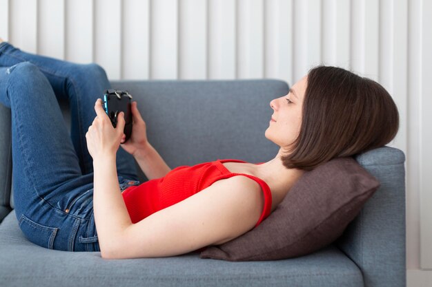 Woman playing a videogame at home