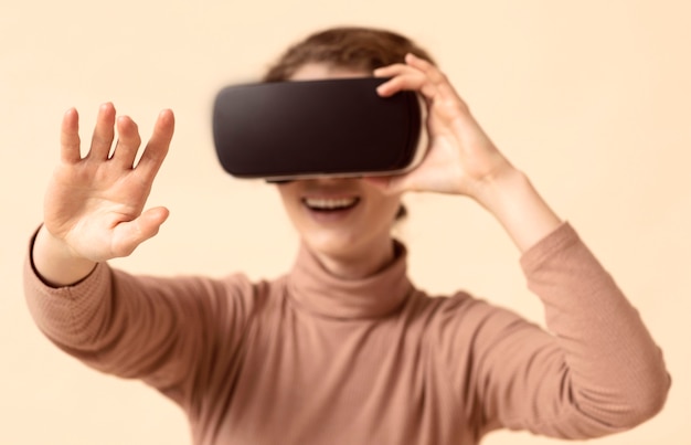 Free photo woman playing on virtual reality headset and reaching her arm