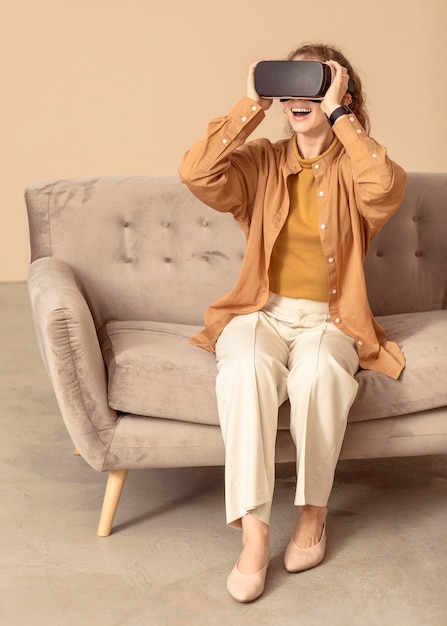 Free Photo woman playing on virtual reality headset sitting on the couch