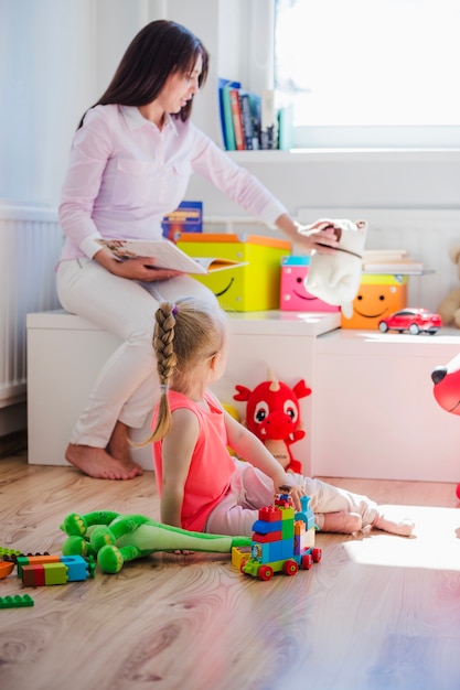 Free photo woman playing with child in playroom