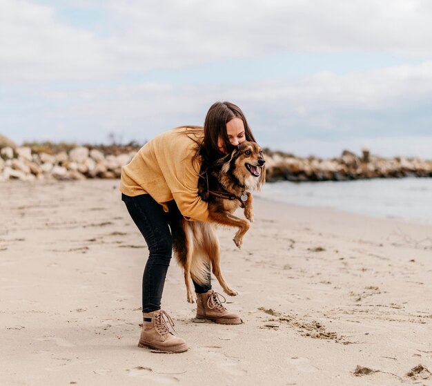 Woman playing with dog at the beach