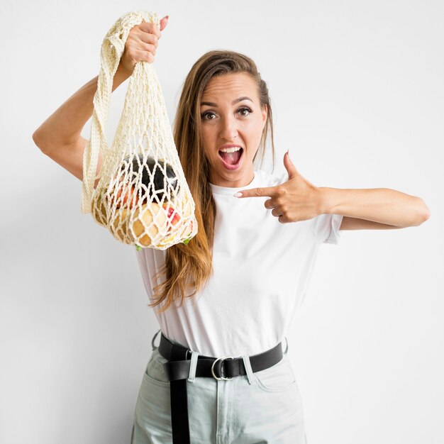 Woman pointing to a bag with healthy goodies