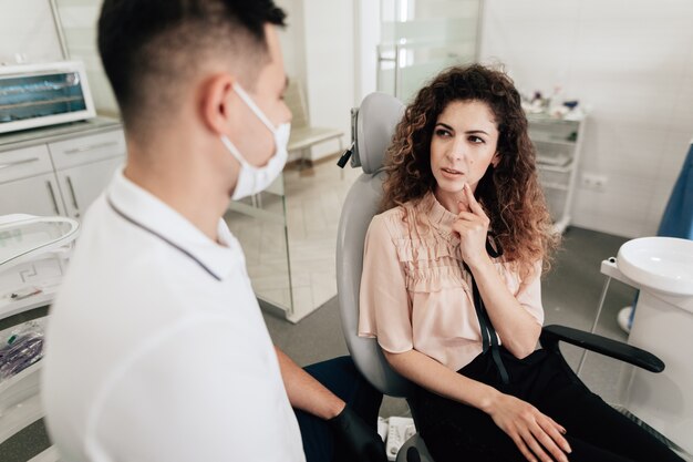 Woman pointing at tooth in dentist office