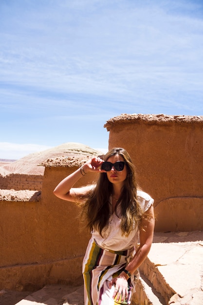 Free photo woman posing at desert ruins under blue sky