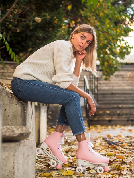 Woman posing sideways in jeans and roller skates