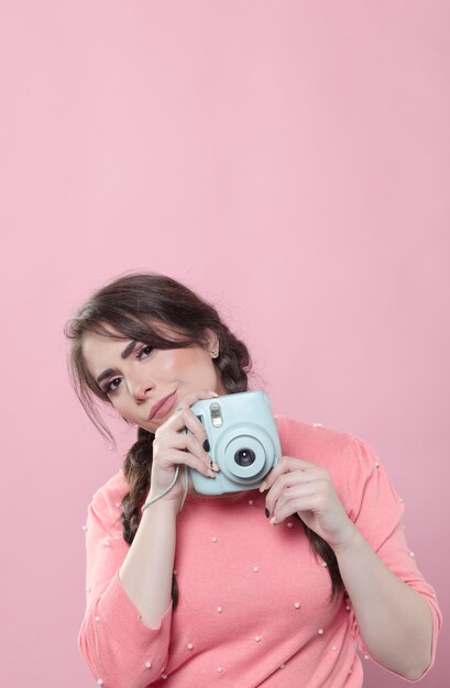 Woman posing while holding camera with copy space