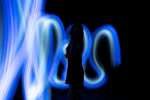 Free Photo woman posing with blue light side view