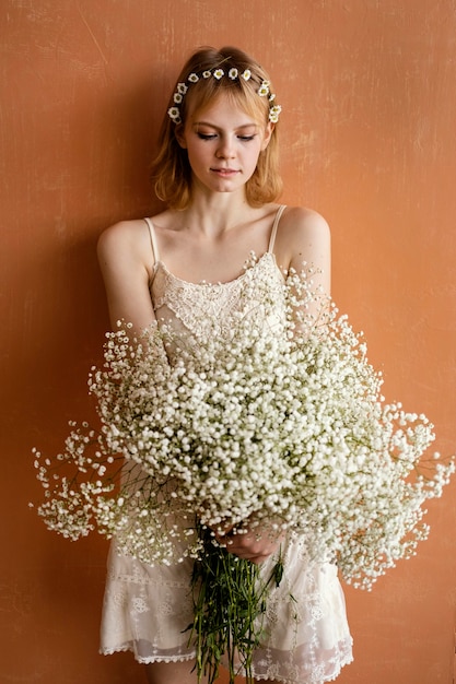 Free photo woman posing with bouquet of beautiful flowers