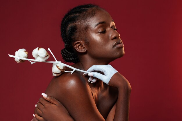 Woman posing with cotton flower side view