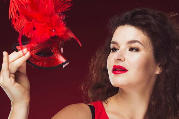 Woman posing with feathered mask