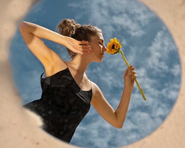 Free photo woman posing with round mirror and flower