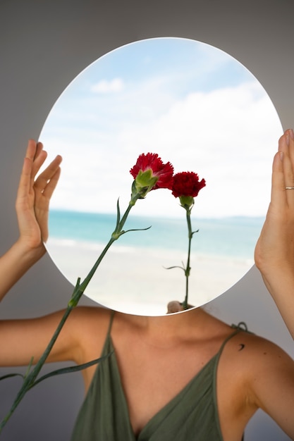 Woman posing with round mirror and flower