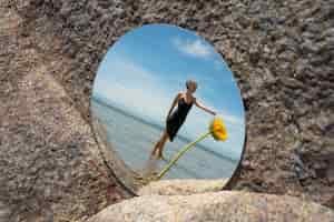 Free photo woman posing with round mirror and flower