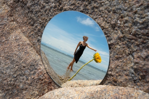 Free Photo woman posing with round mirror and flower