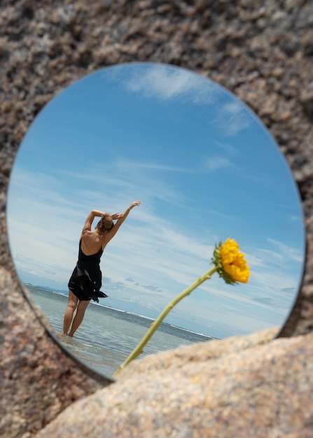 Free Photo woman posing with round mirror and flower