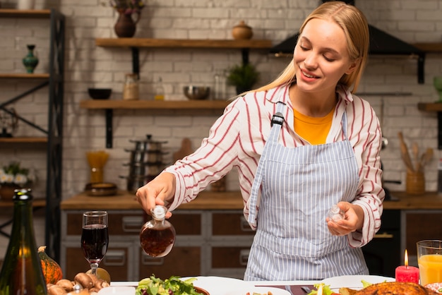 Woman pouring oil dressing on food