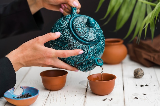 Free photo woman pouring tea in teacup