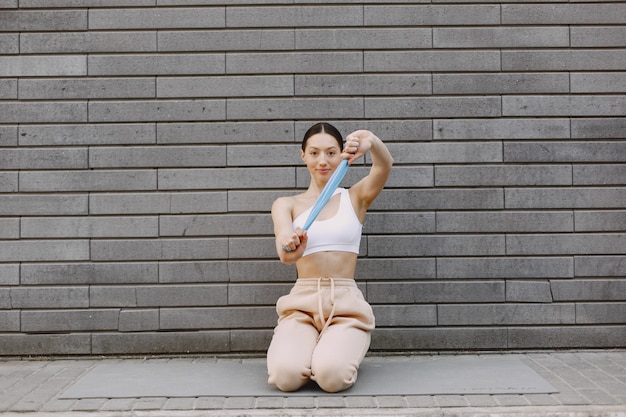 Free photo woman practicing advanced yoga against a dark urban wall