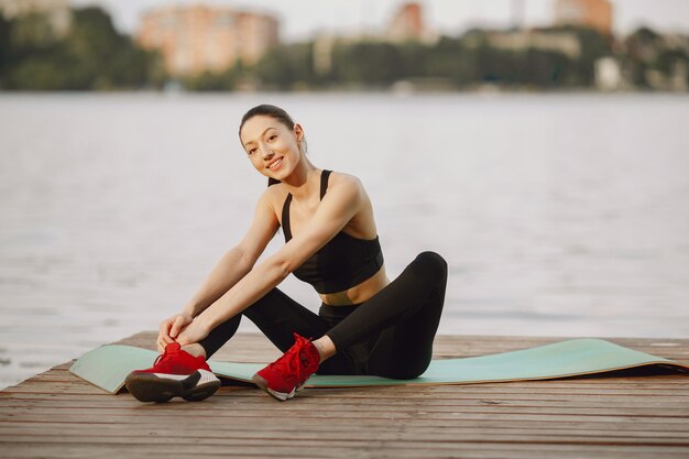 Woman practicing advanced yoga by the water