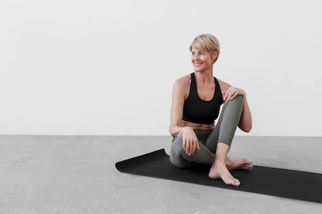 Woman practicing sport on yoga mat