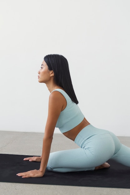 Woman practicing sport on yoga mat