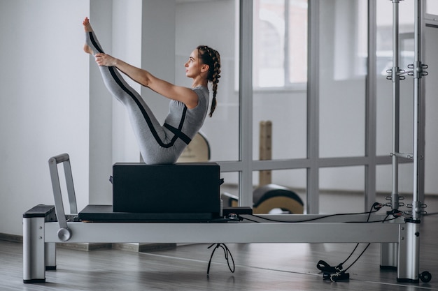 Woman practising pilates in a pilates reformer