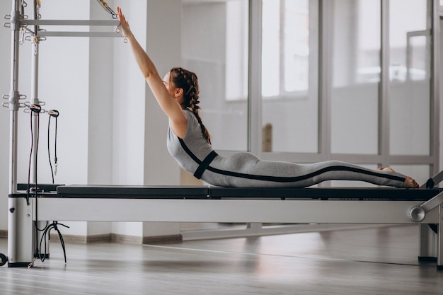 Woman practising pilates in a pilates reformer