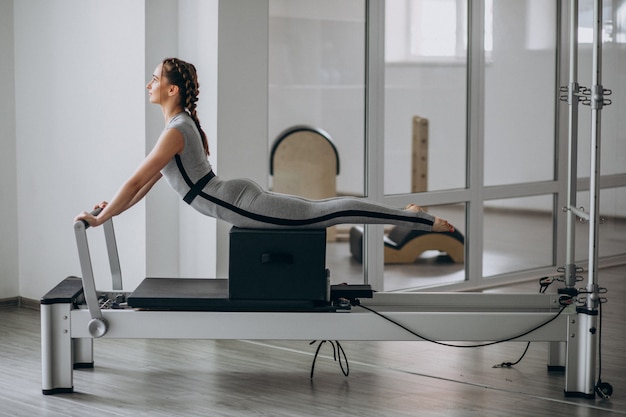 Woman practising pilates in a pilates reformer