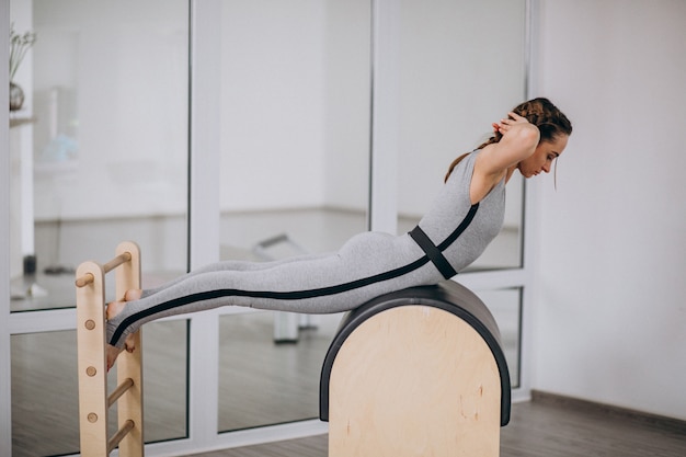 Free photo woman practising yoga with equipment